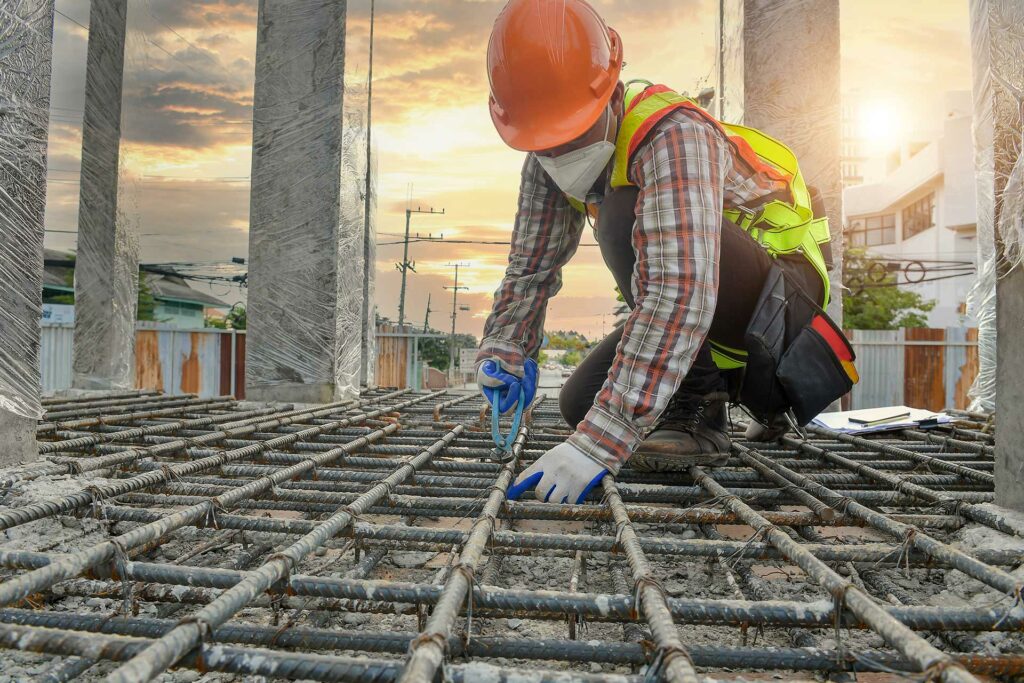 Construction worker laying rebar.