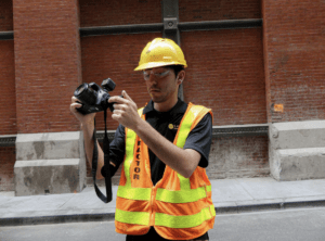 A Saltus technician using a camera to document the condition of a building that's near a construction site.