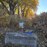 An Aeroqual Dust Sentry installed on a concrete block in the area surrounding a construction zone.